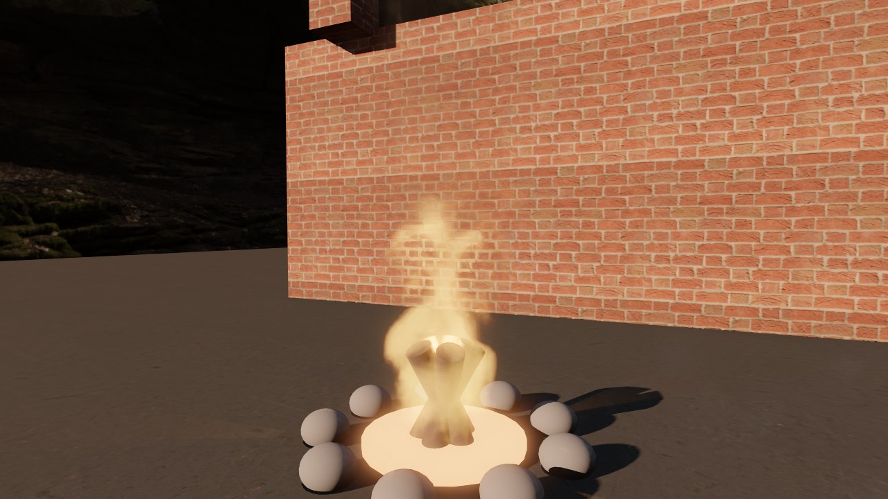 A campfire in a ring of stones next to a brick wall, at night
